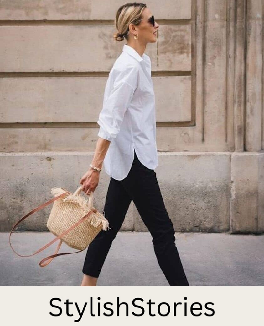 Woman wearing black skinny jeans, a white button down and Birkenstock sandals walks through the city.