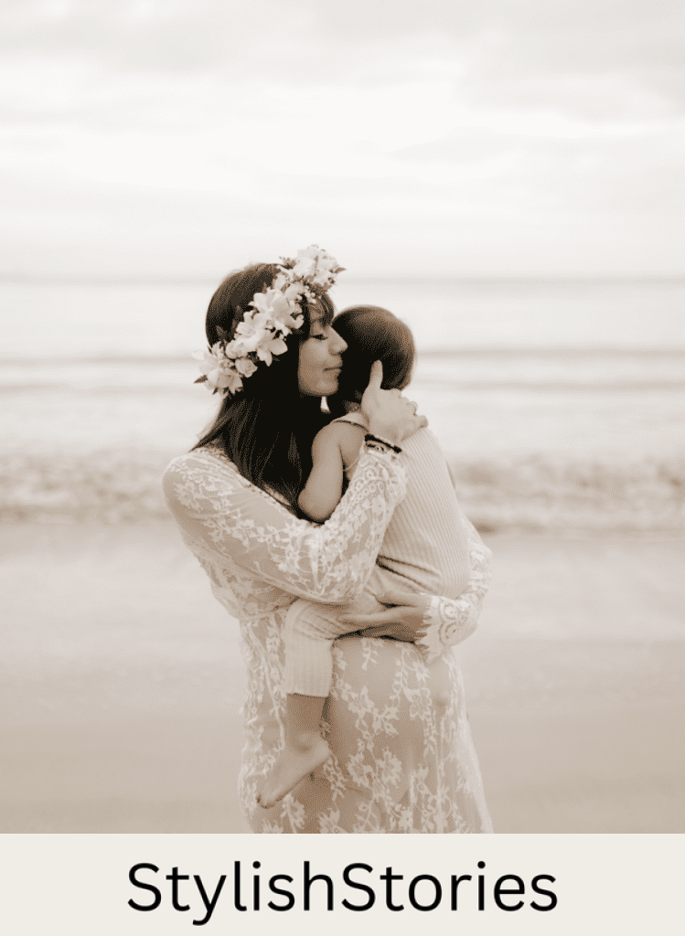 image of a pregnant woman in a sheer lace dress holding a small child in her arms on the beach