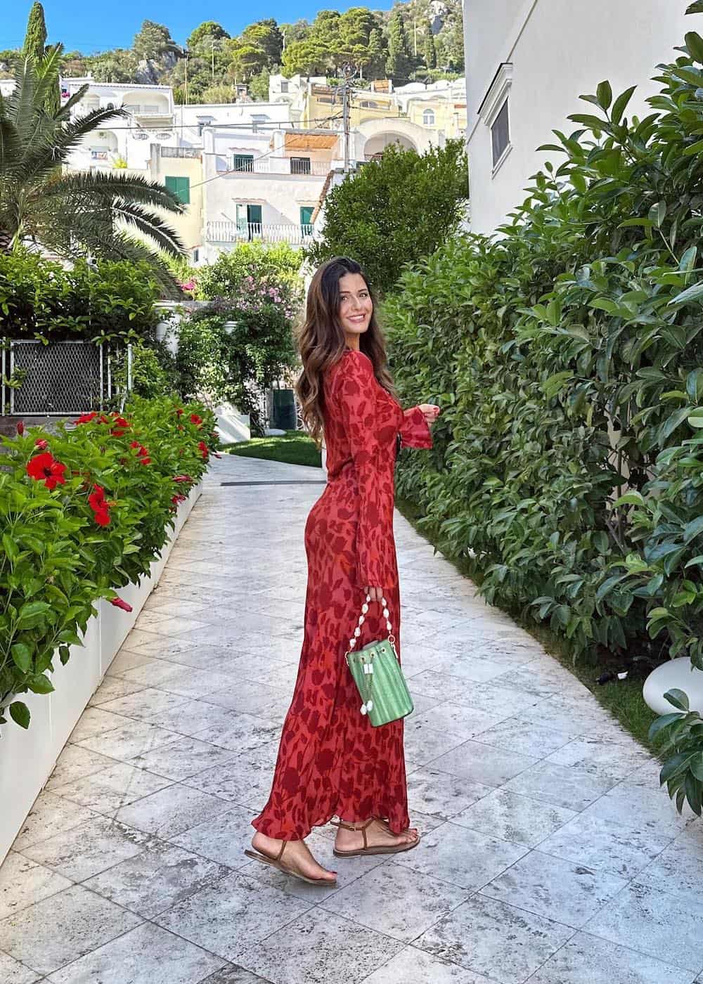 a woman wearing a red patterned long-sleeve maxi dress