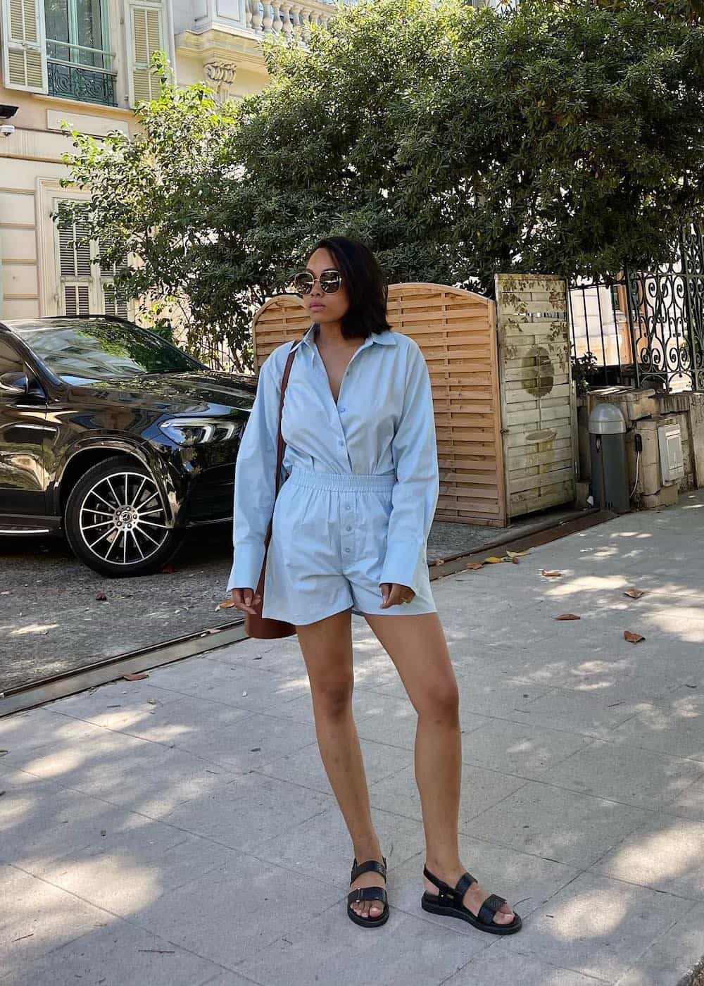 a woman wearing a sky blue matching set featuring shorts and a button-up