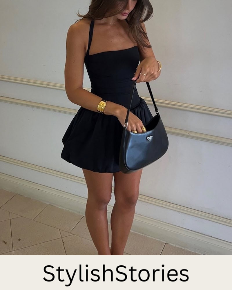 Woman wearing a black bubble hem dress with sandals.
