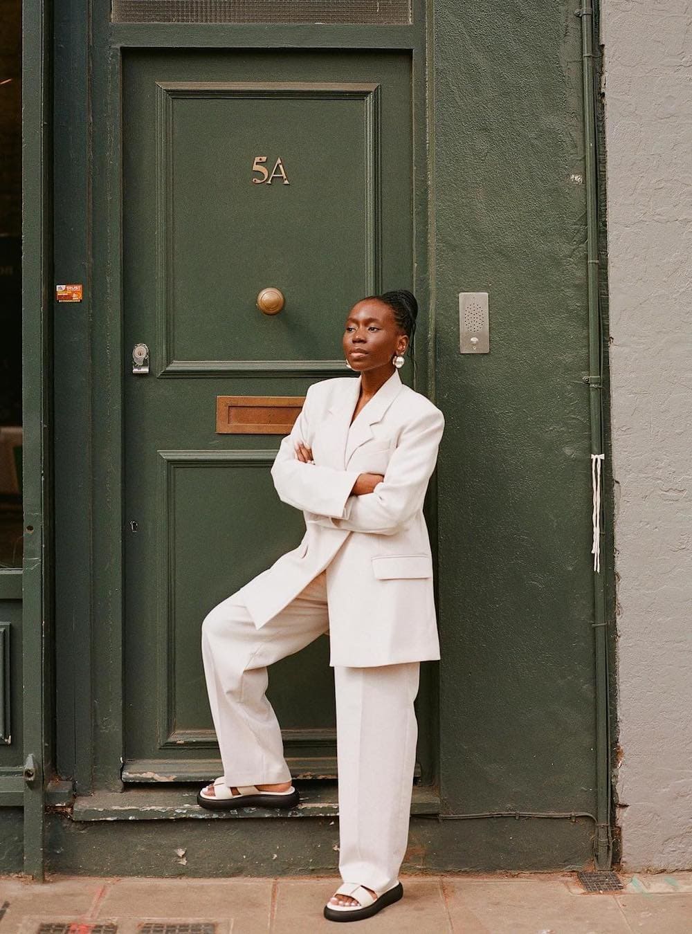 Woman wearing a white suit with white sandals.