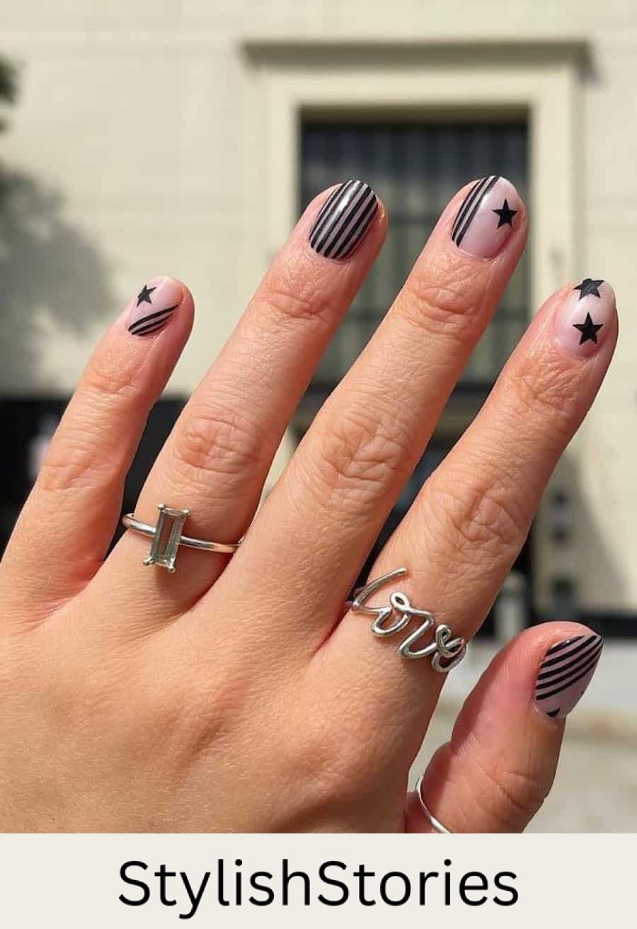 short nude round nails with black stripes and stars