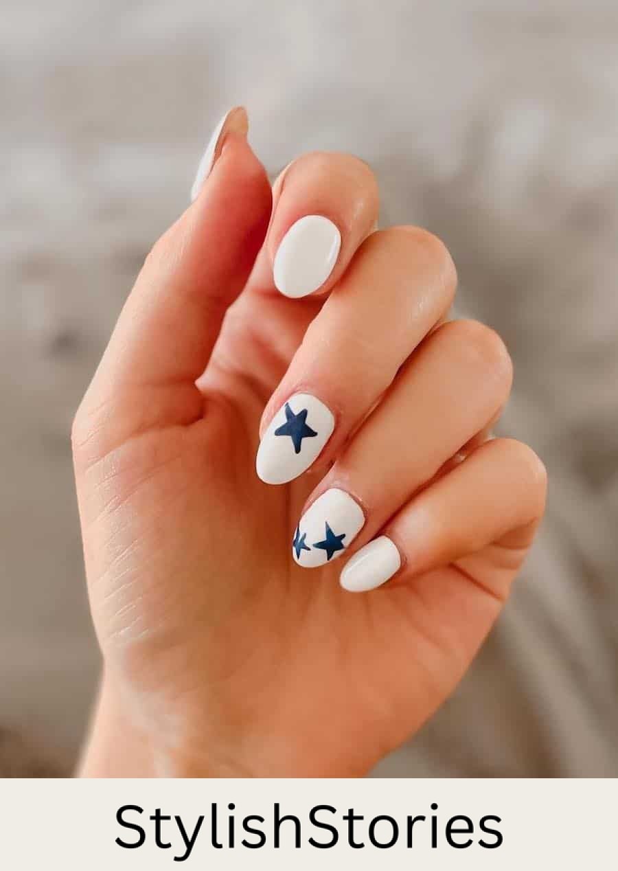 medium white almond nails with navy blue star accent nails