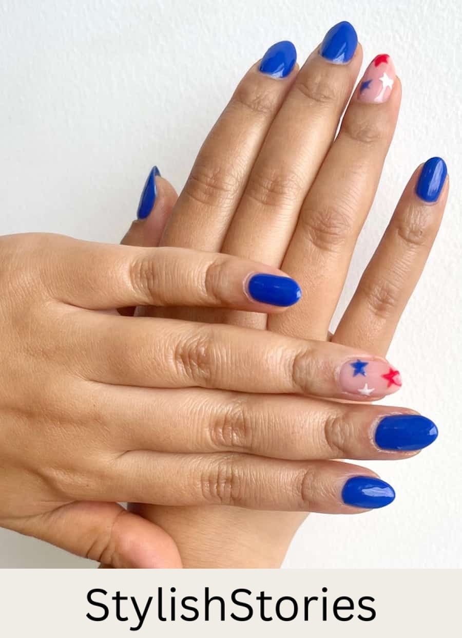 short round blue nails with a nude accent nails featuring red, white, and blue stars