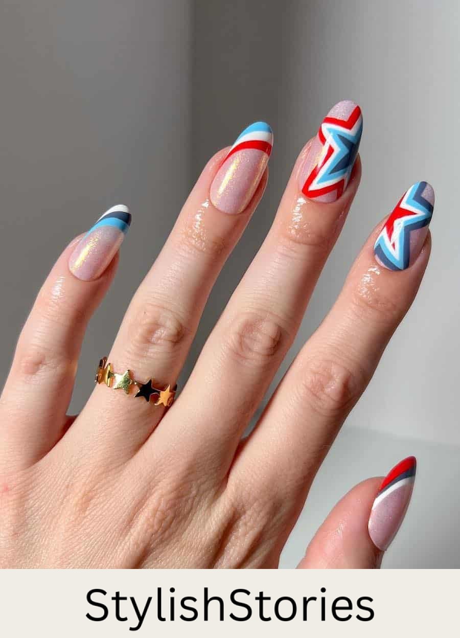 long round nails with shimmering pink polish and red, white, and blue striped French tips and star accent nails