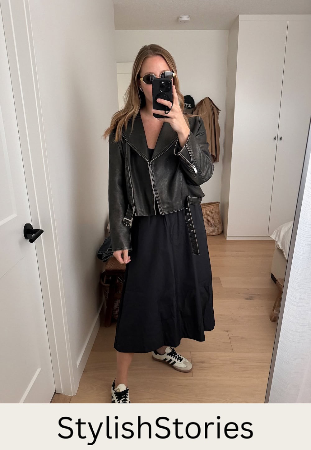 Christal wearing a black midi dress with a black leather jacket and sambas.