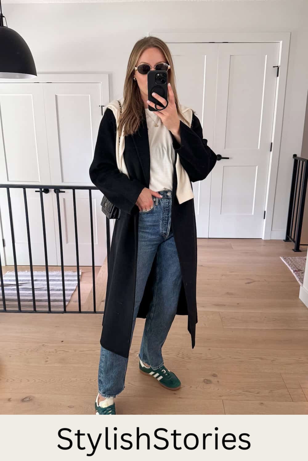 Christal wearing jeans with a white tee and a long black cardigan with sambas.