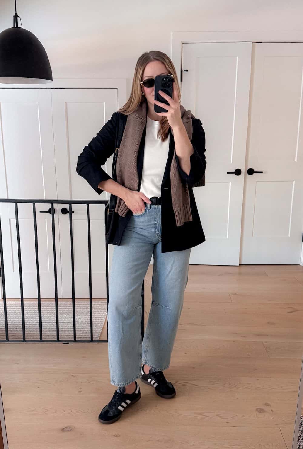 Christal wearing jeans, a white tee and a black cardigan with sambas.