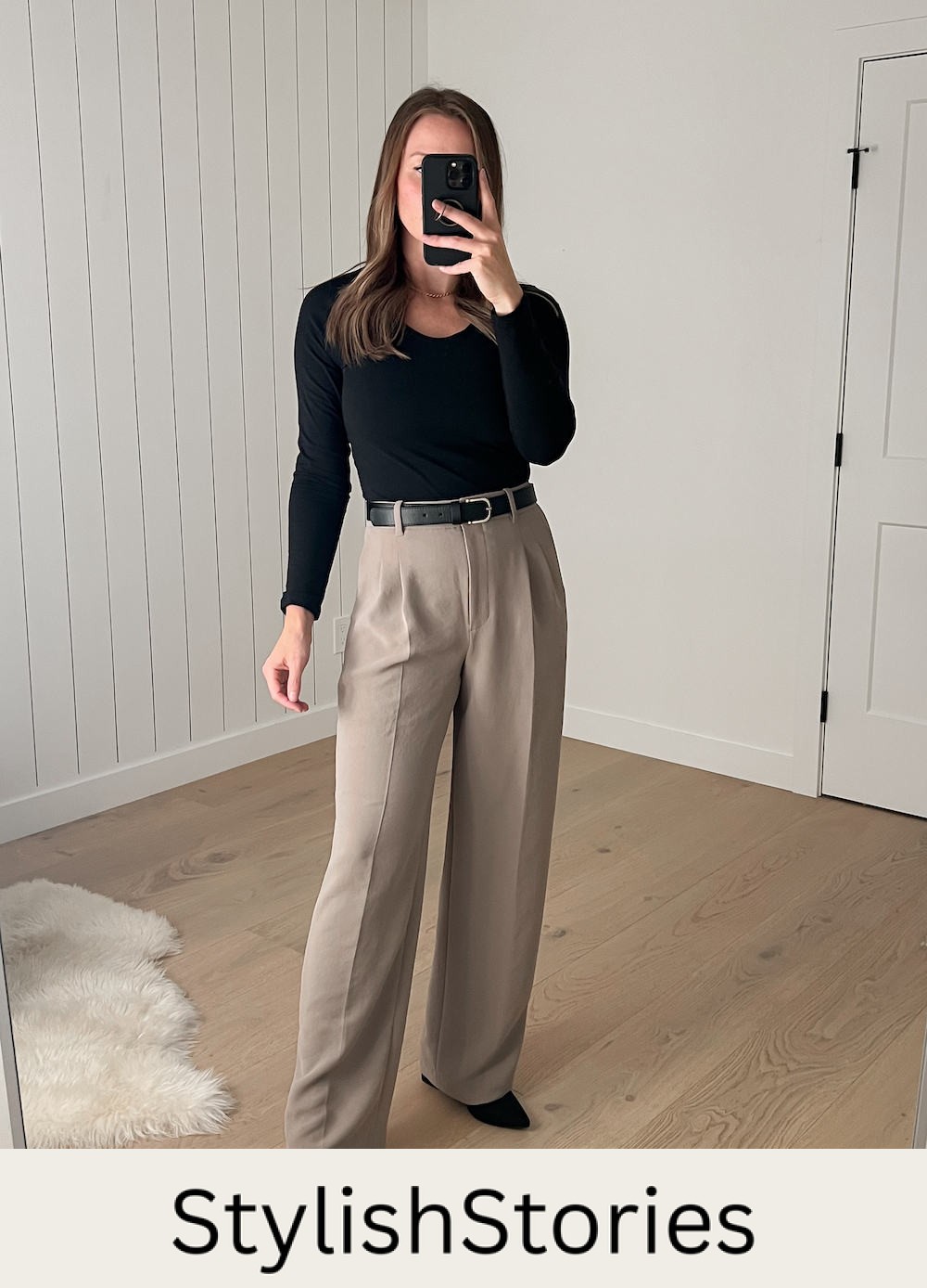 Christal wearing the Aritzia Effortless Pants in Nomad Taupe with a black long-sleeved top and a black belt with black pumps