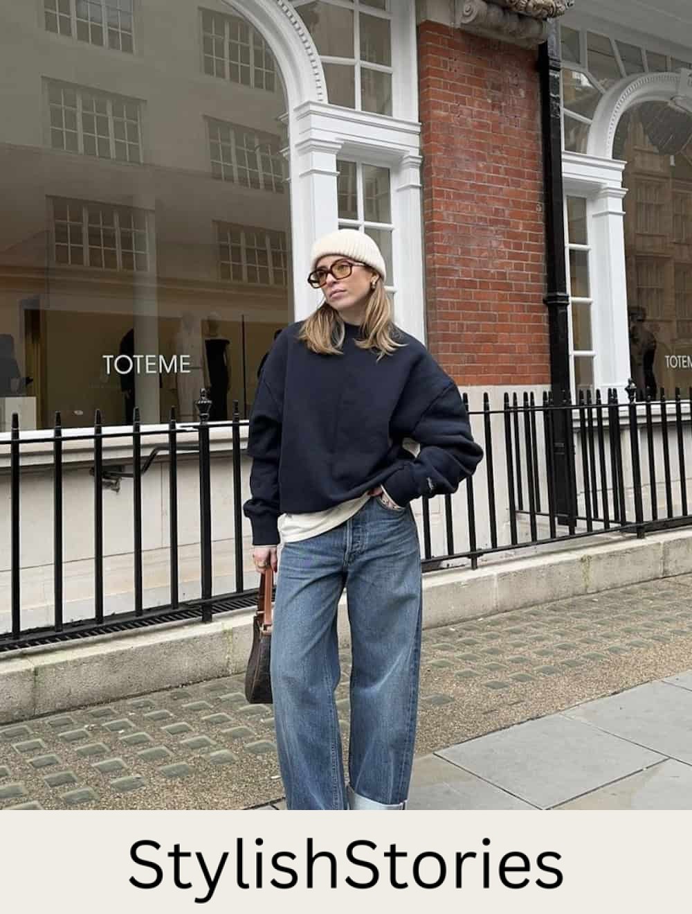 Woman wearing baggy jeans and an oversized crewneck sweater with chunky boots.