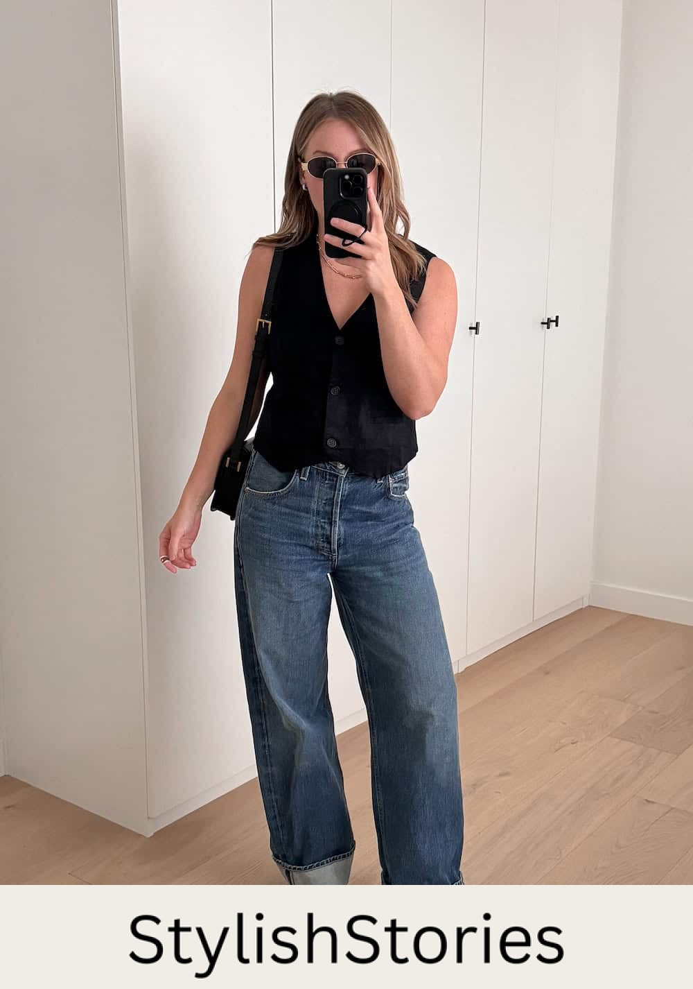 Christal wearing jeans, black heeled sandals and a black vest top.