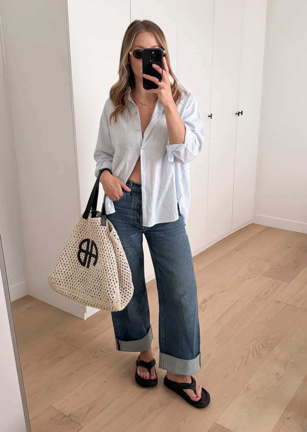 Christal wearing baggy jeans, black sandals and a linen button down.