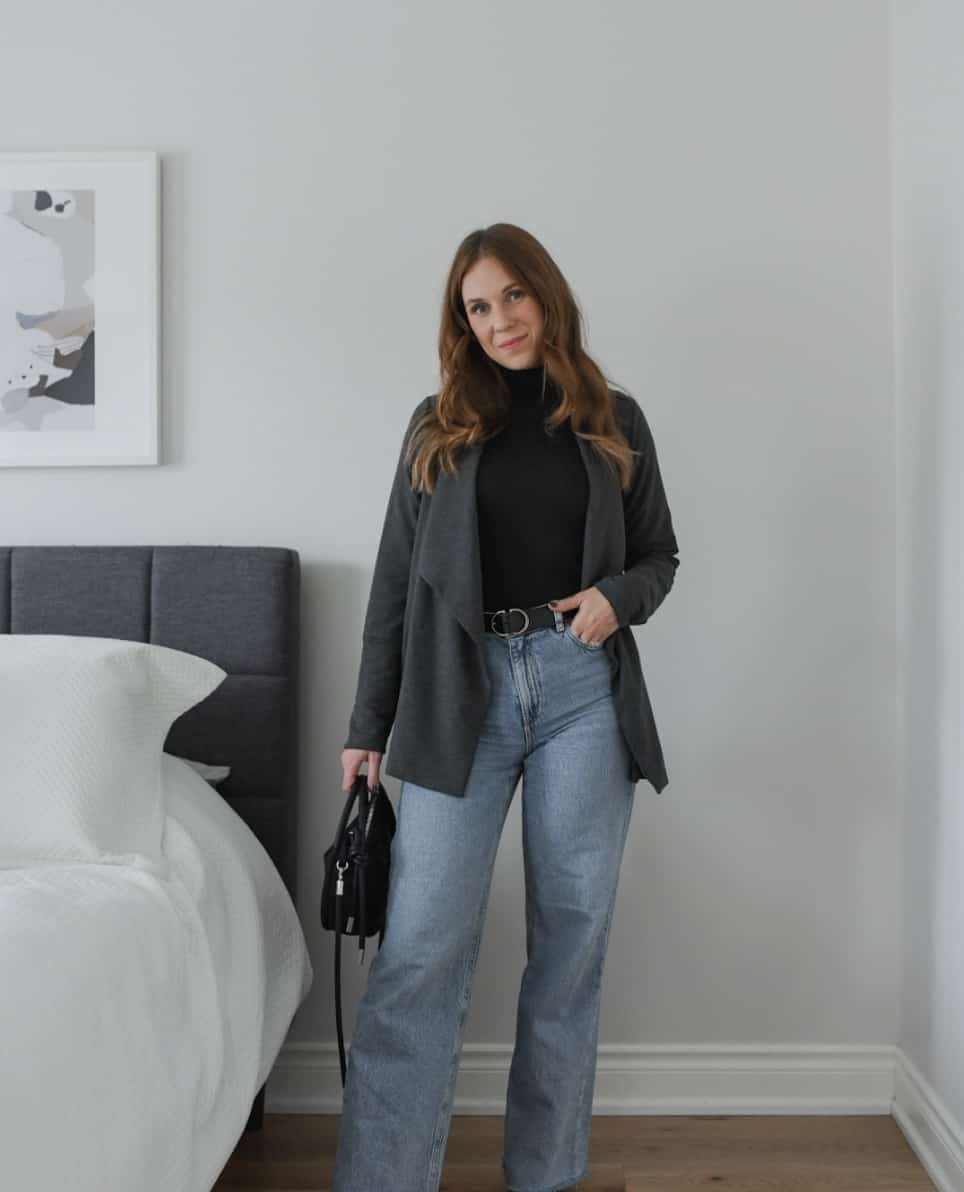 Image of a woman wearing a grey blazer over a black top with jeans