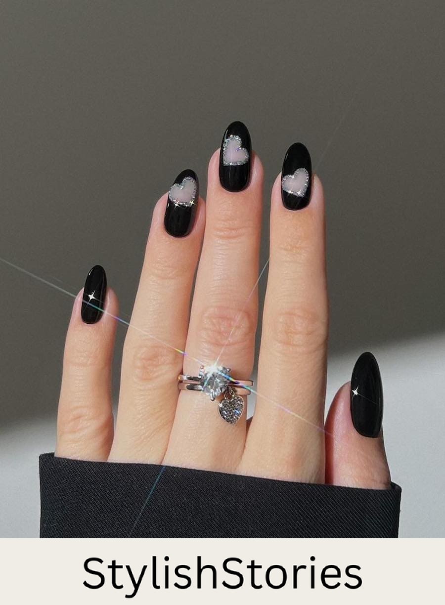 Medium round black nails with negative space hearts outlined by silver glitter