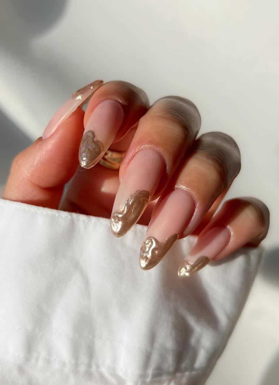 Long matte nude almond nails with wavy molten gold tips