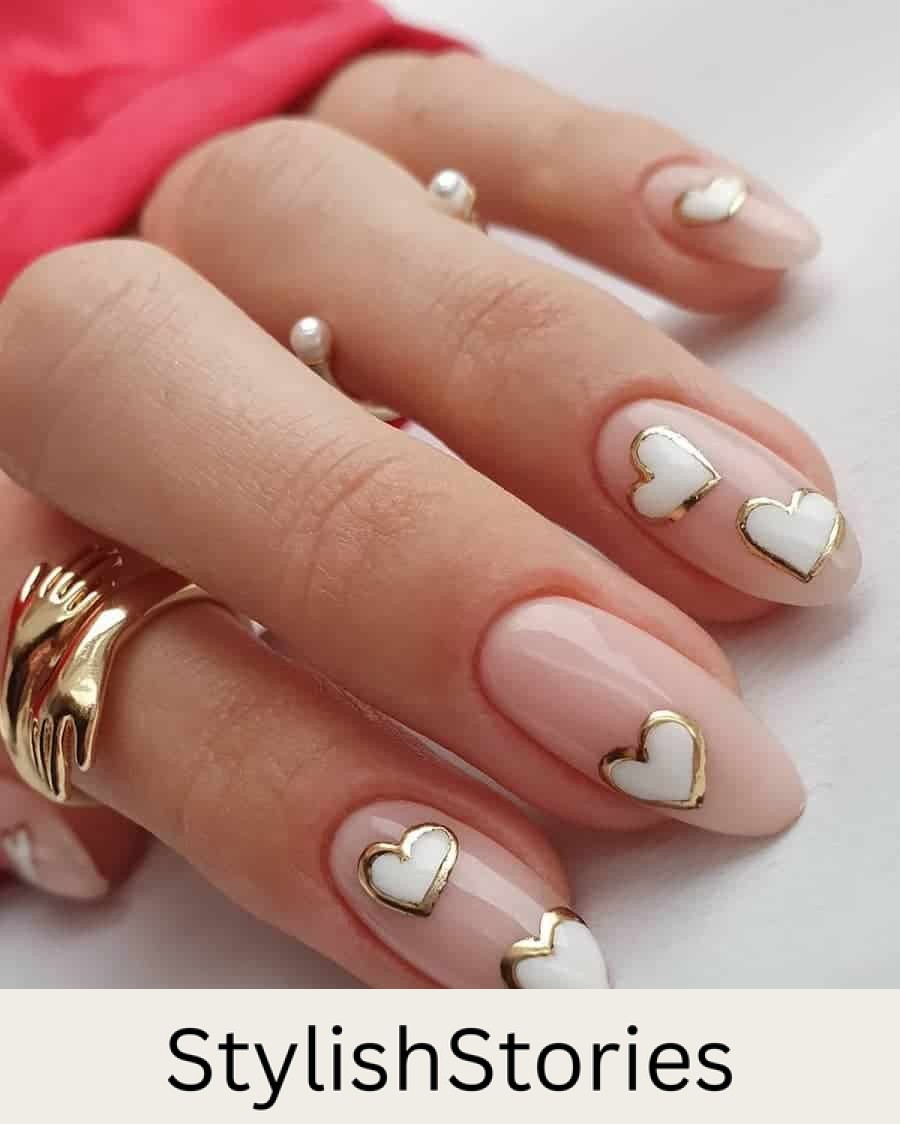 Medium pastel pink almond nails with white hearts with metallic gold borders