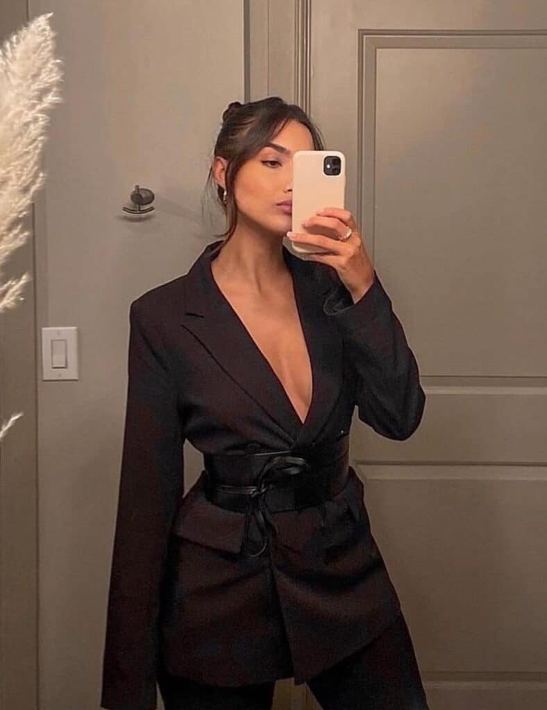 woman wearing a long black blazer top belted with black pants