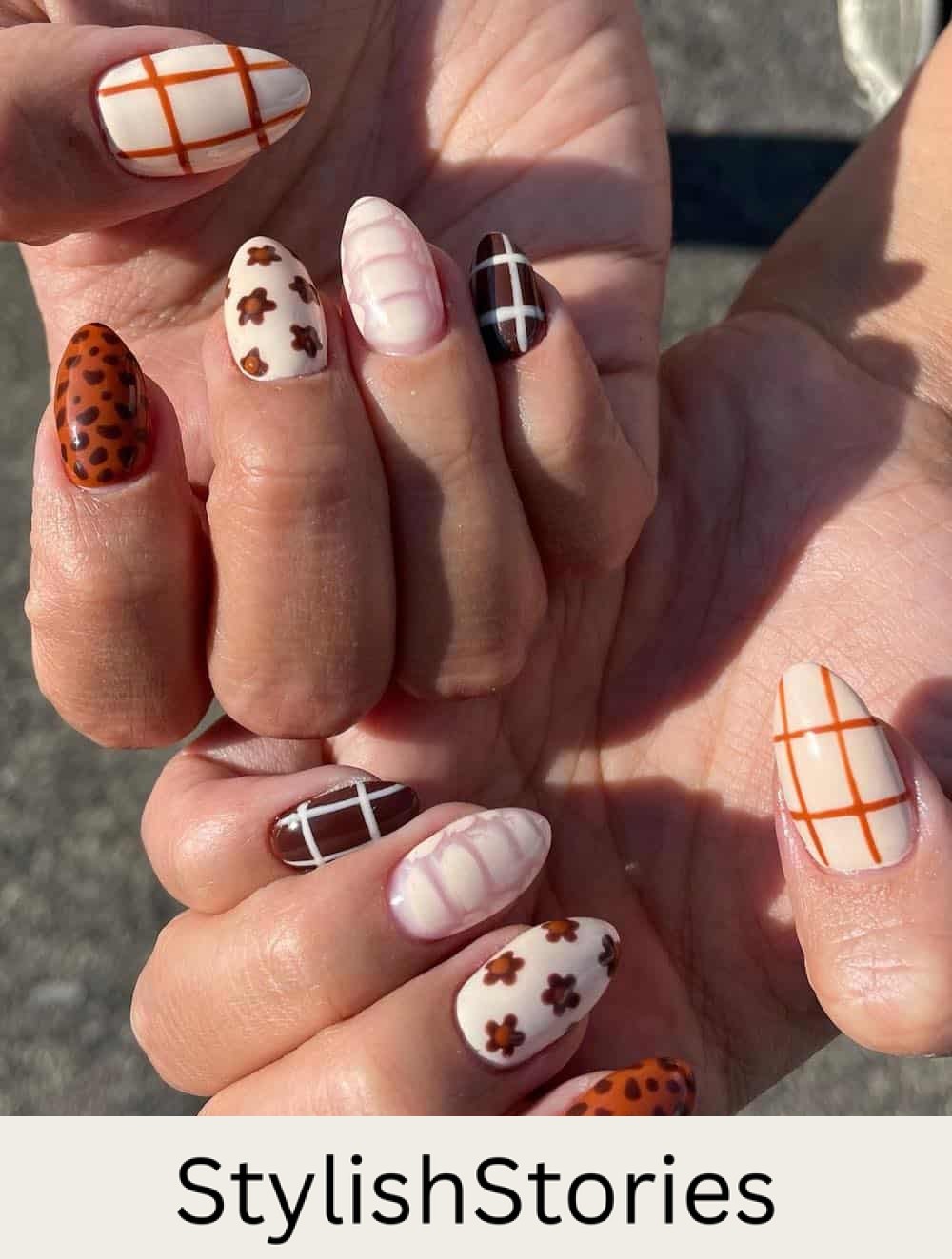 short almond collage nails with burnt orange, cream, and brown polish featuring floral designs, plaid, and animal print
