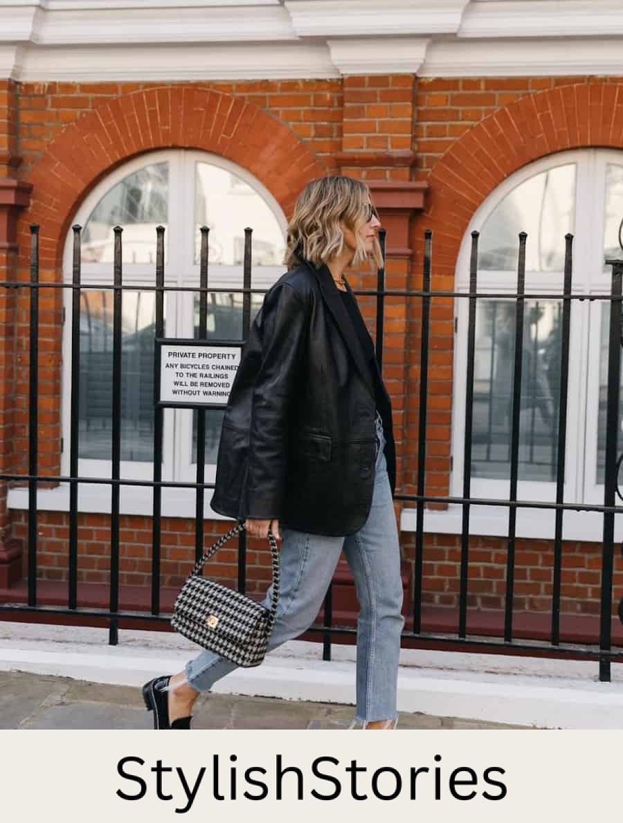 image of a woman wearing an oversized black leather blazer, jeans, and black chunky loafers