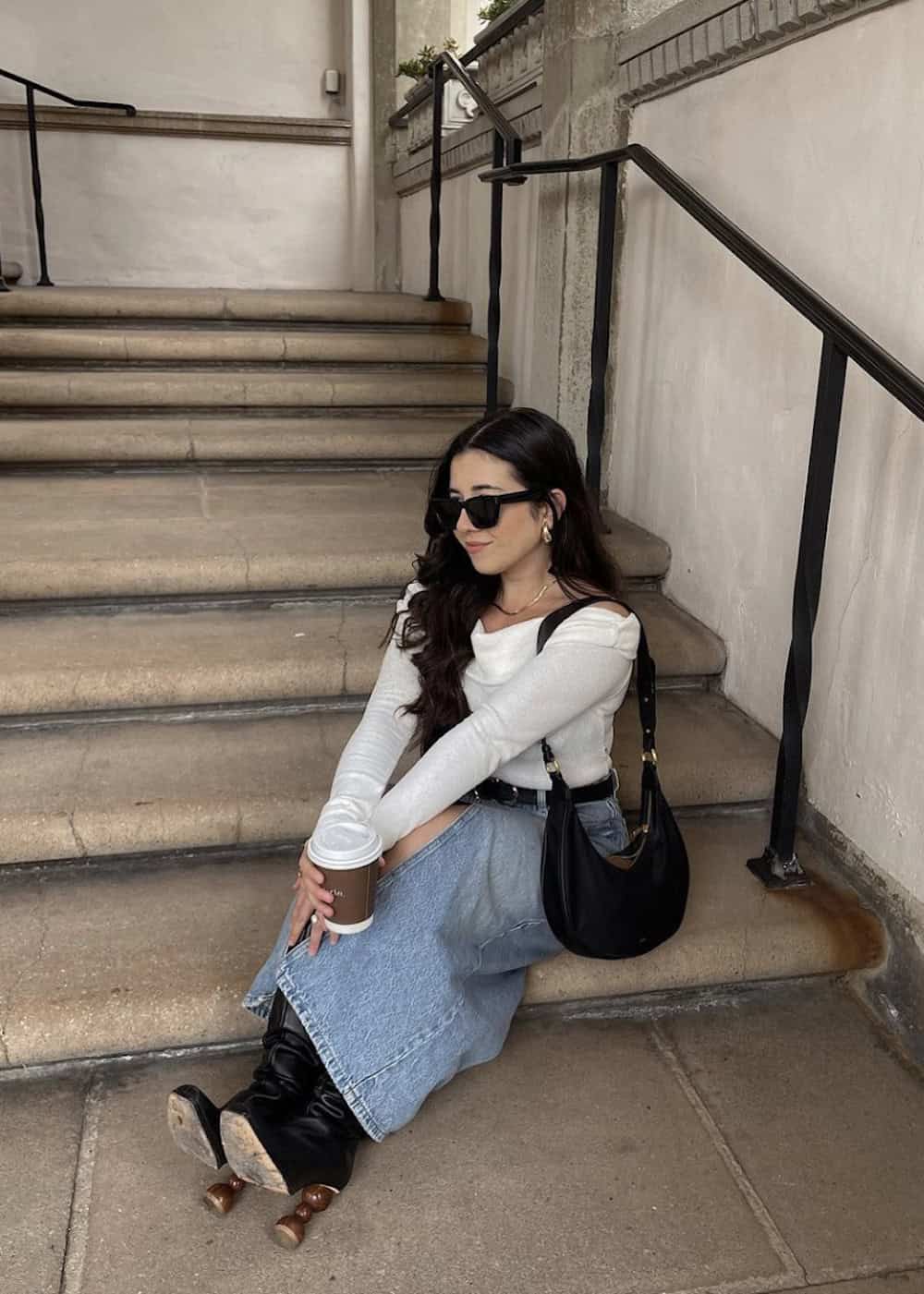 Woman wearing a denim maxi skirt with an off the shoulder top and black booties.