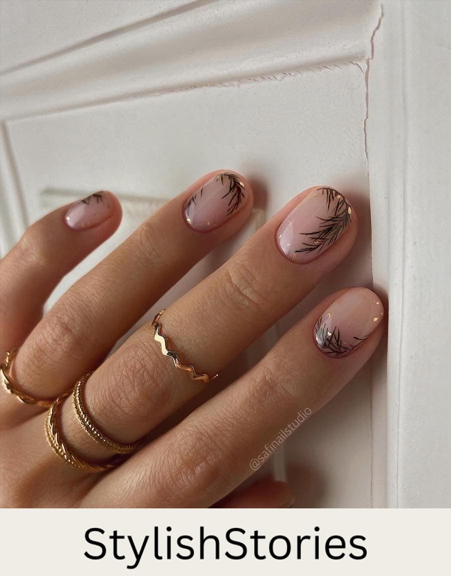 A hand with short round nails painted with a glossy topcoat with pine nail art and gold flakes