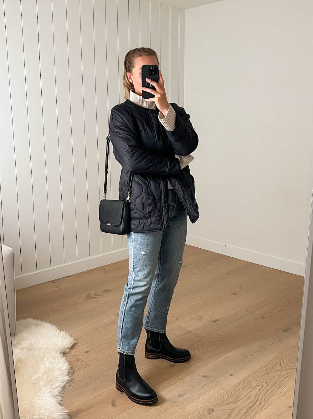 Christal wearing jeans with chelsea boots and a black puffer jacket.