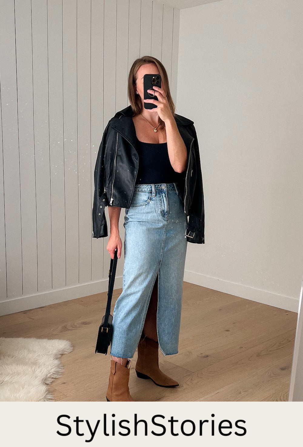 Christal wearing a black leather jacket over a black bodysuit with a long denim skirt and suede cowboy boots for a country concert outfit