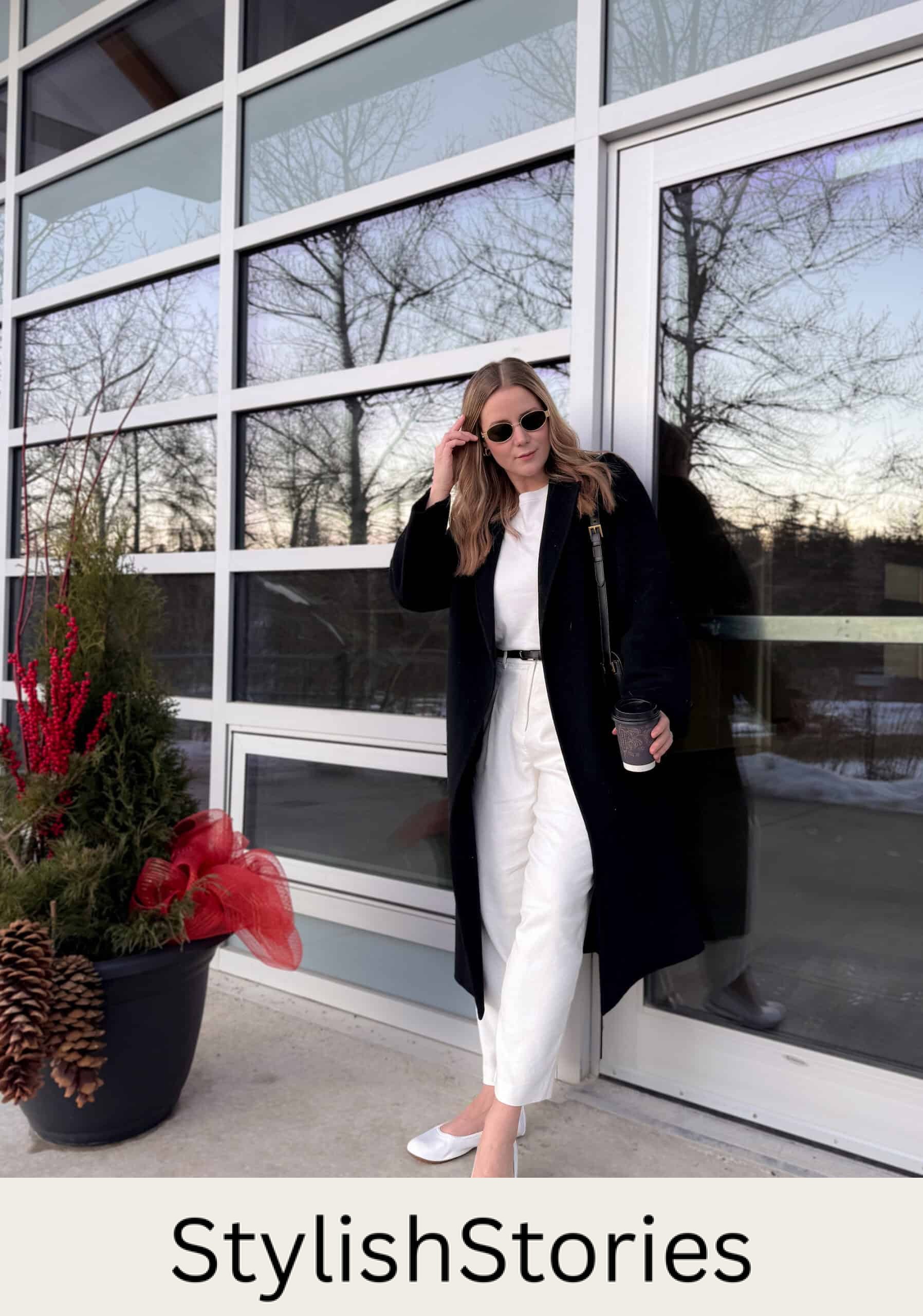 Christal wearing white pants, a white tee and a black cardigan with white ballet flats.