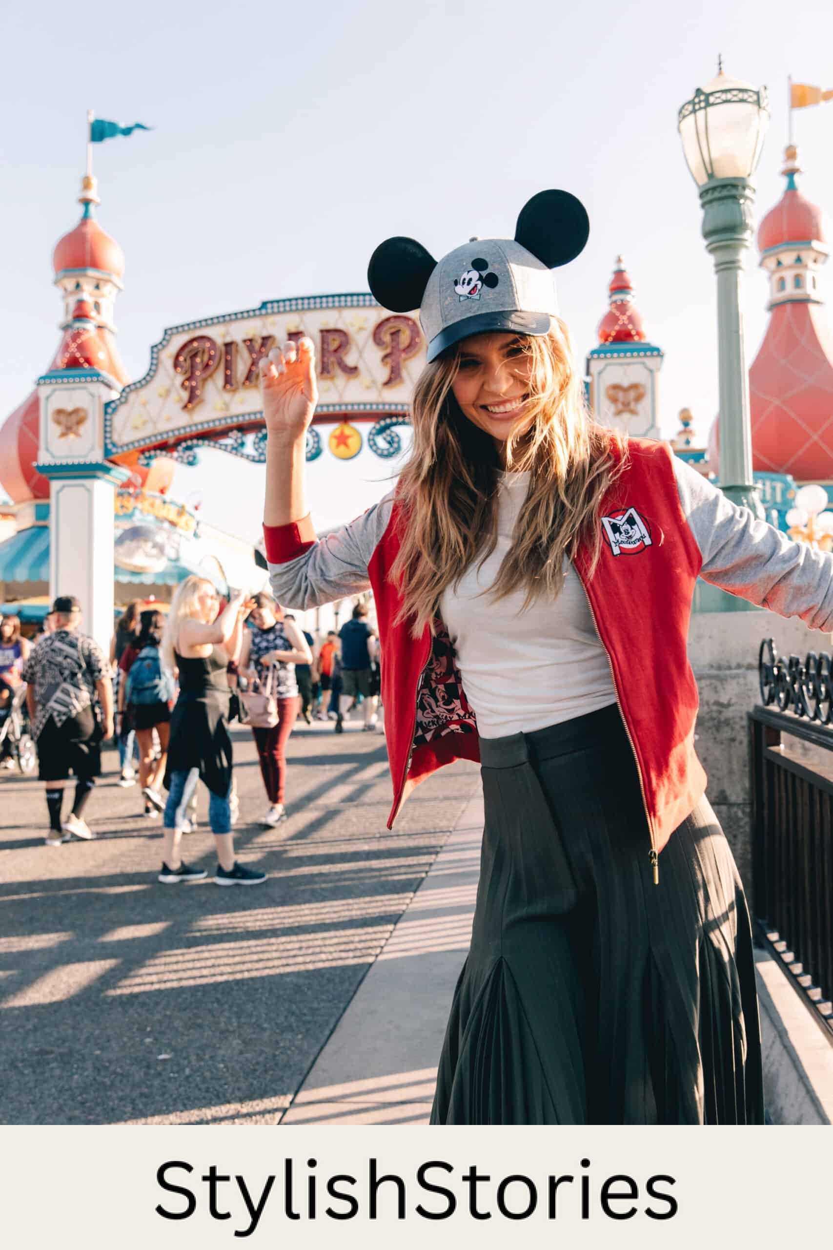 woman at disneyland wearing a red Disney varsity jacket and a black skirt