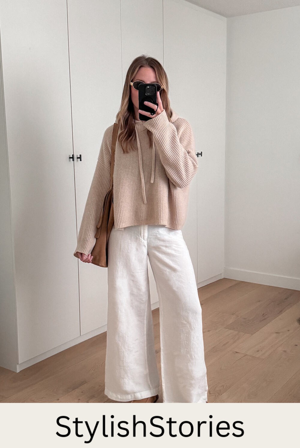 Christal wearing white wide leg jeans and a beige oversized sweater.