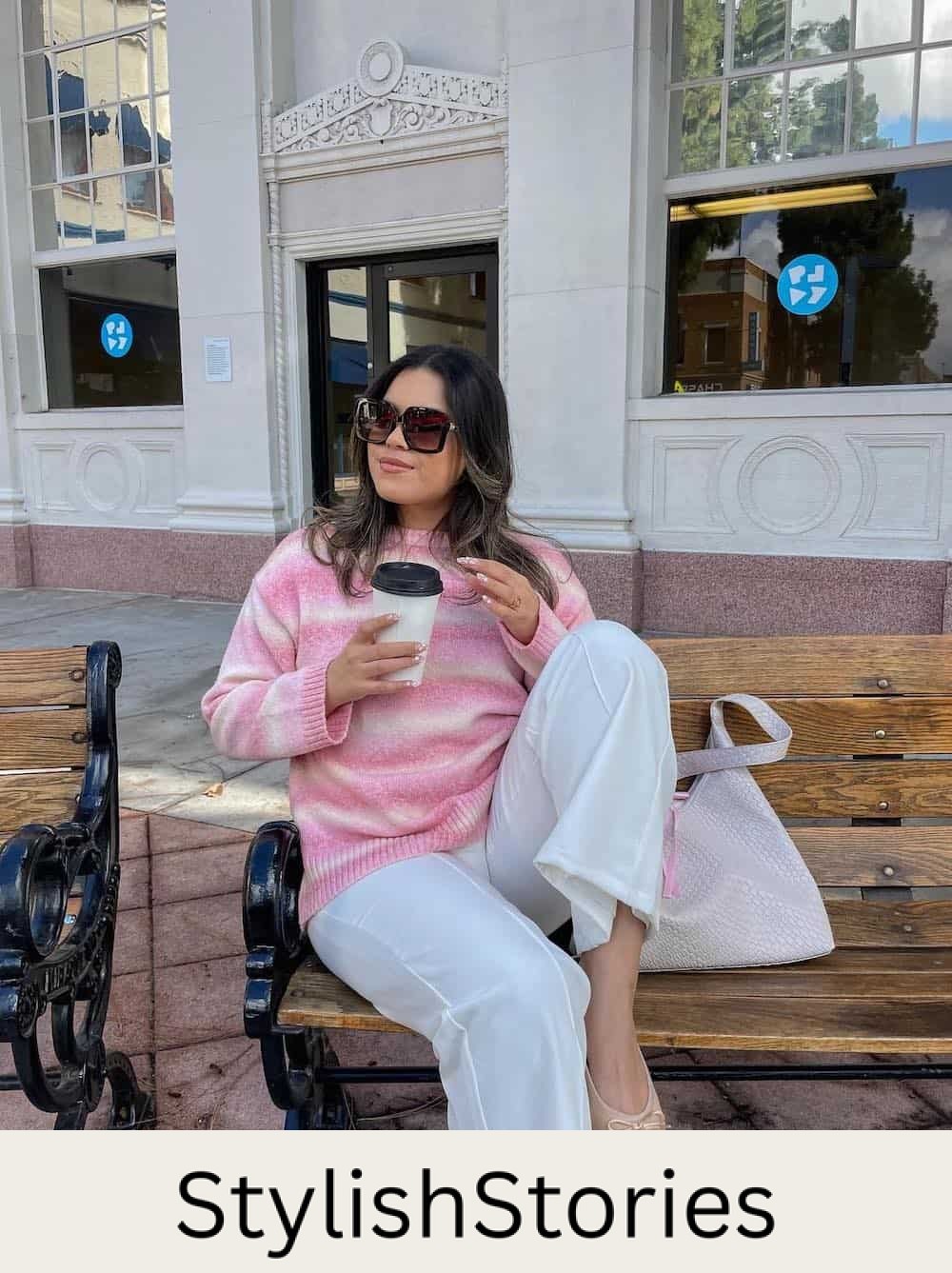 Woman wearing white pants with a pink and white sweater.