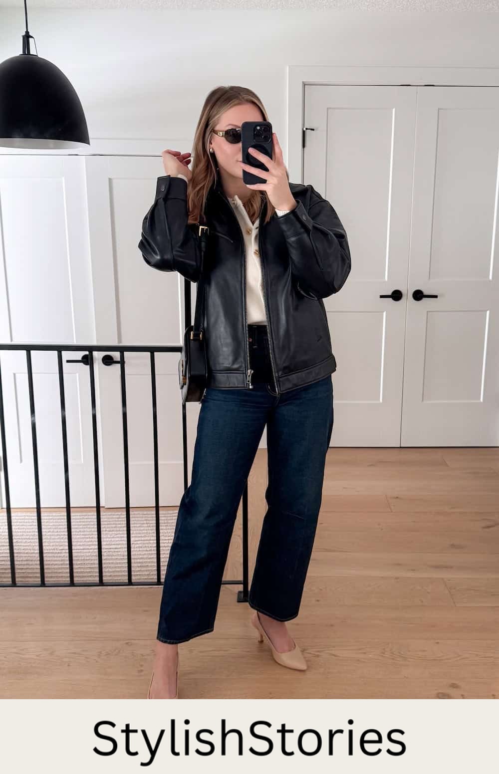 Christal wearing jeans, nude pumps, a white sweater and a black leather jacket.