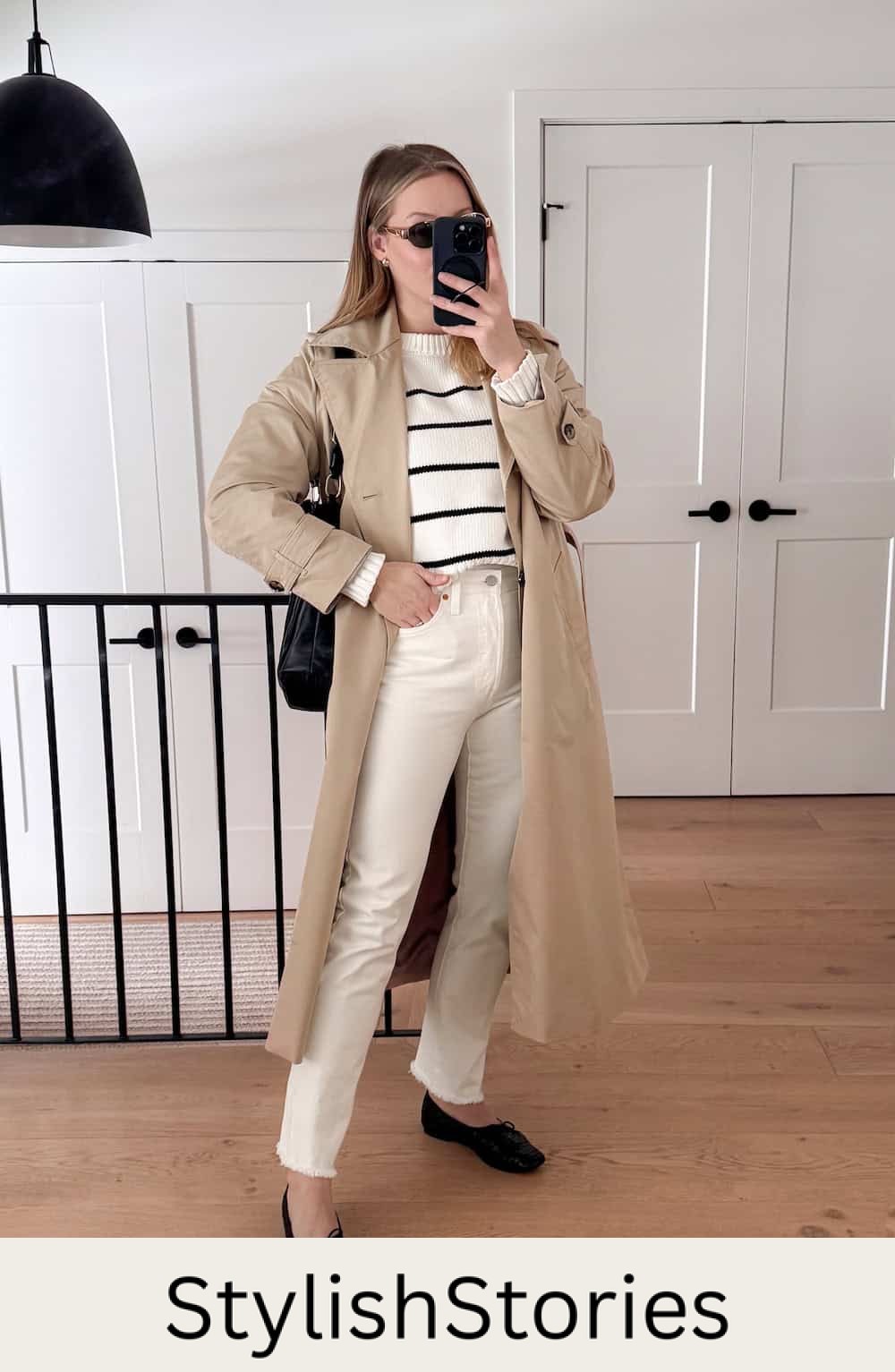Christal wearing white jeans, a white and black sweater, black flats and a trench coat.
