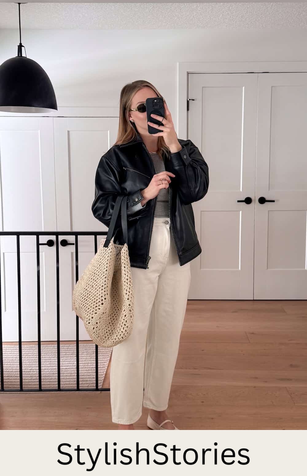 Christal wearing white jeans, a grey top, a black leather jacket and white shoes.