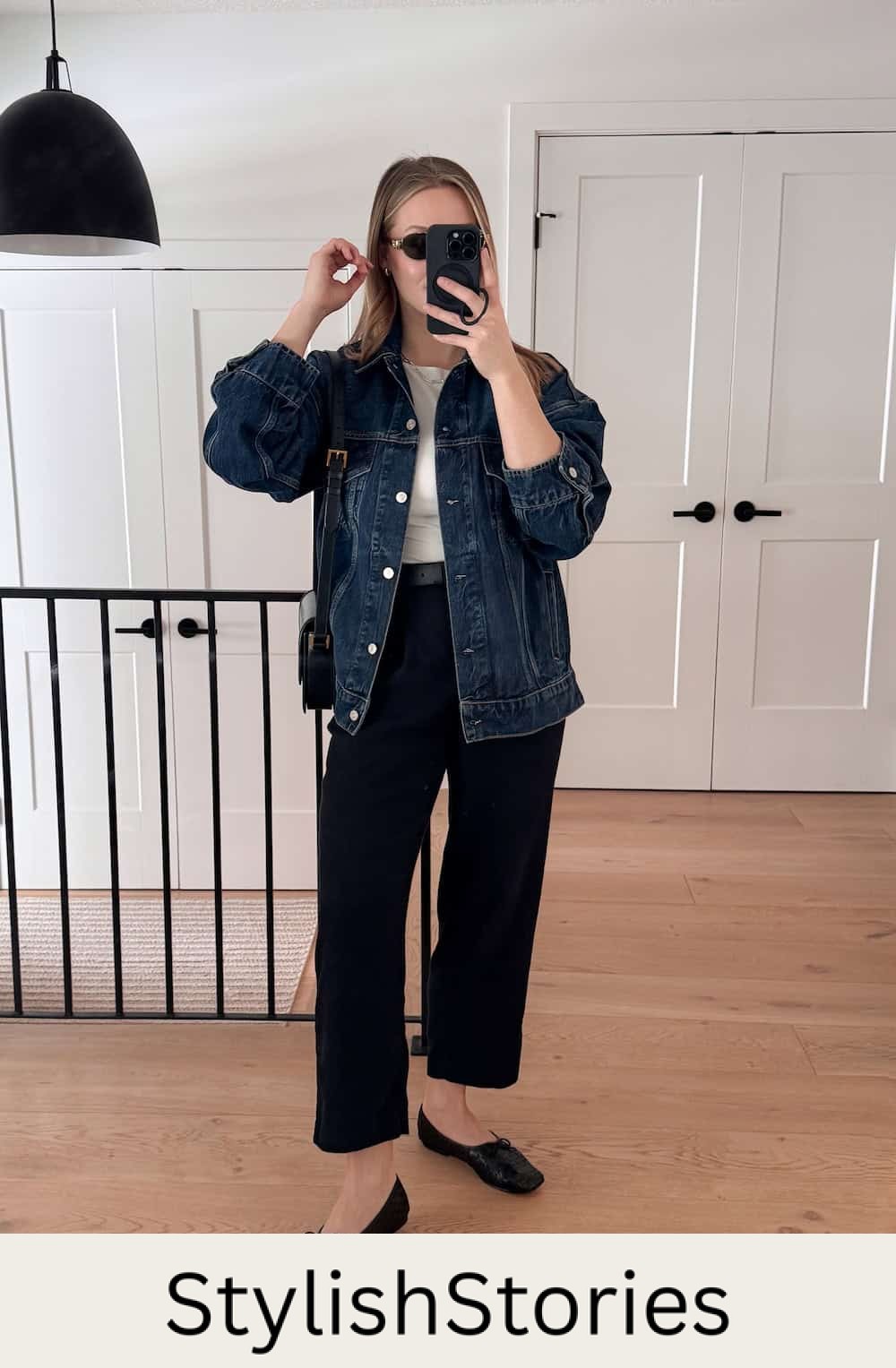 Woman wearing black pants with a white t-shirt and a denim jacket.