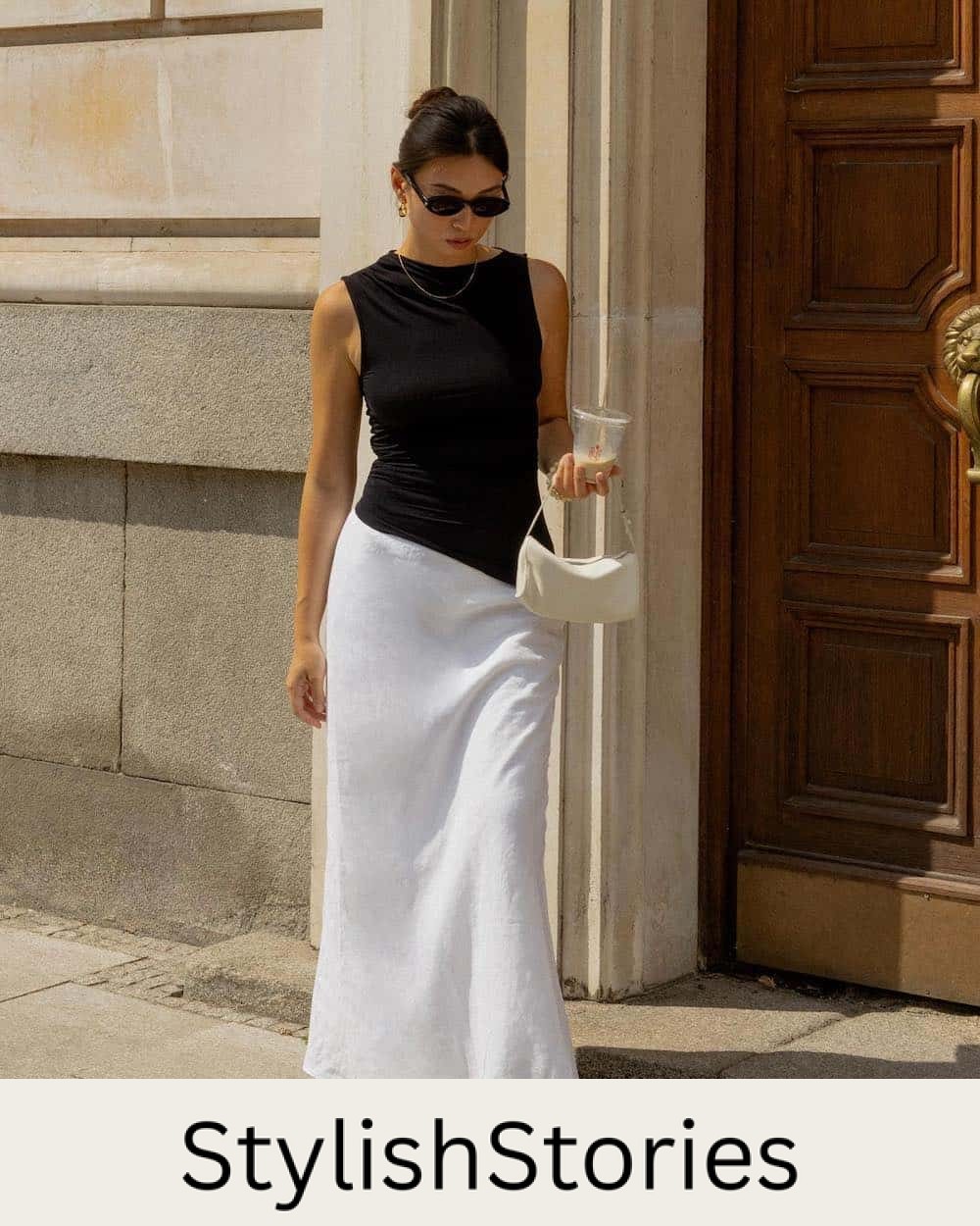 Woman wearing a long linen skirt with a black tank and black flats.