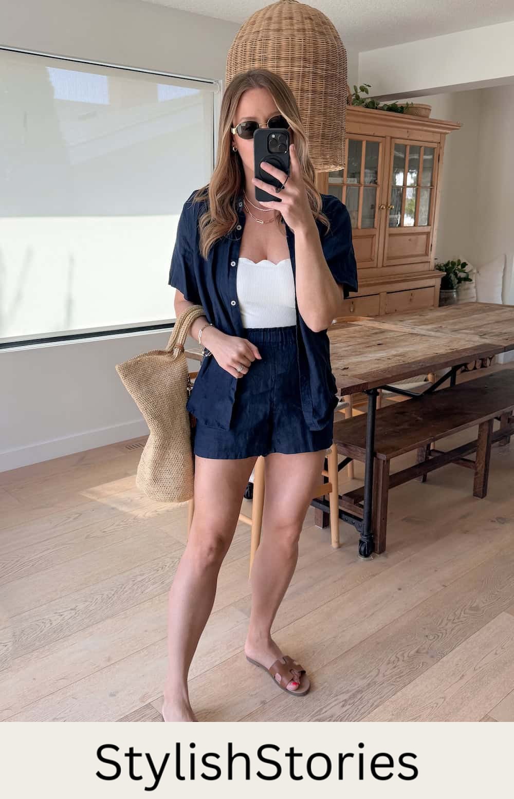Christal wearing navy shorts with a white bodysuit and a navy button down.
