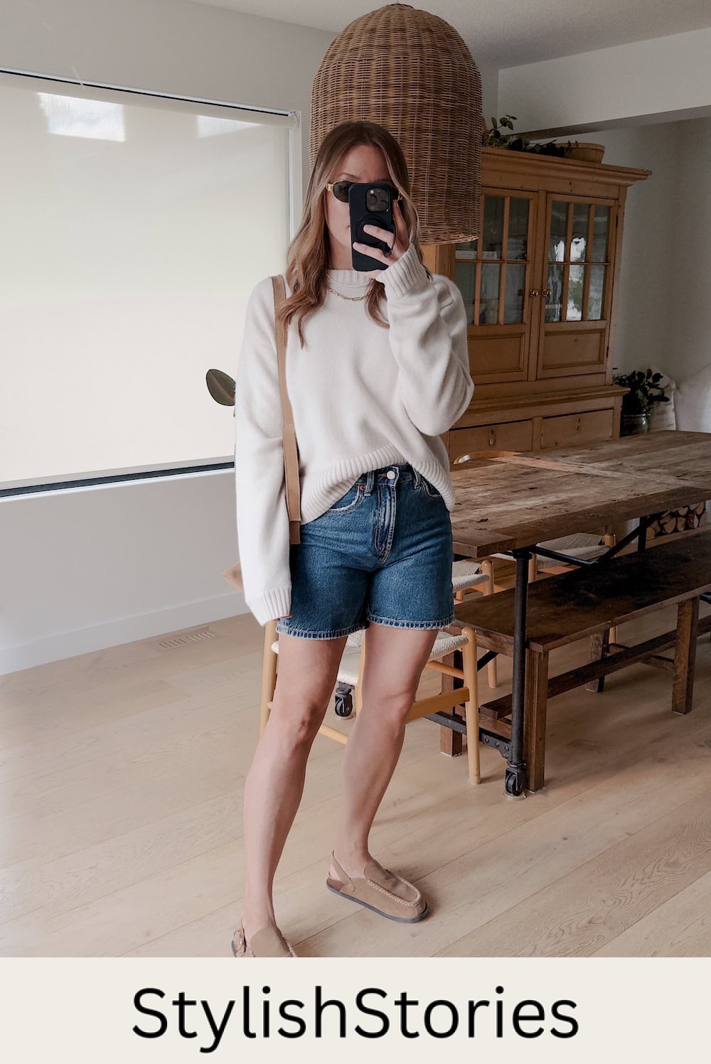 Christal wearing denim shorts with a white sweater and cozy shoes.