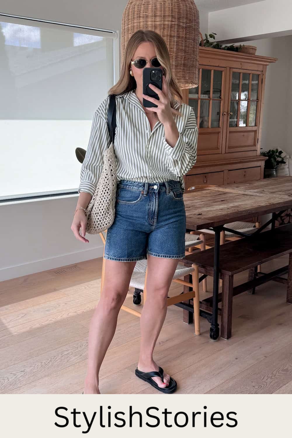 Christal wearing denim shorts with a green and white striped button down and sandals.
