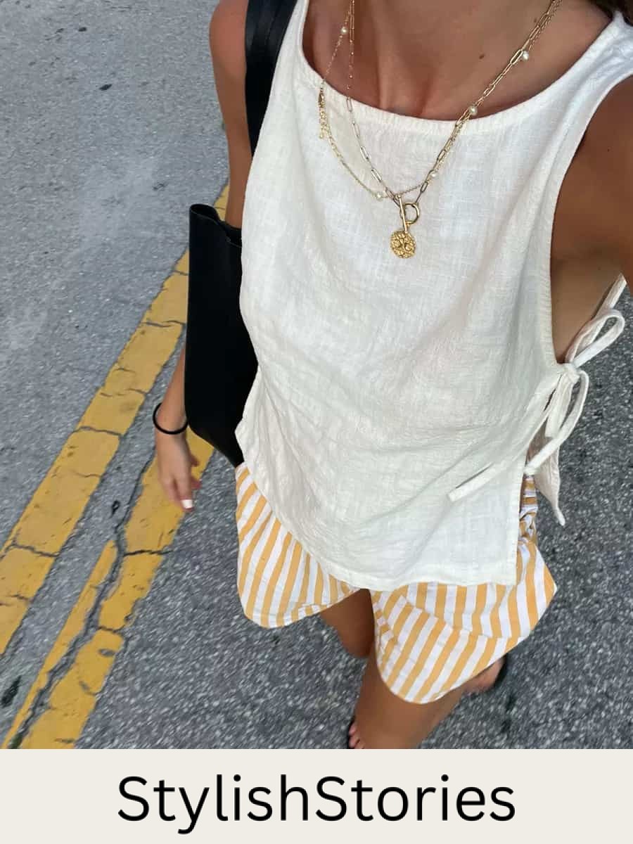 Woman wearing striped linen shorts and a linen tank top with gold accessories.