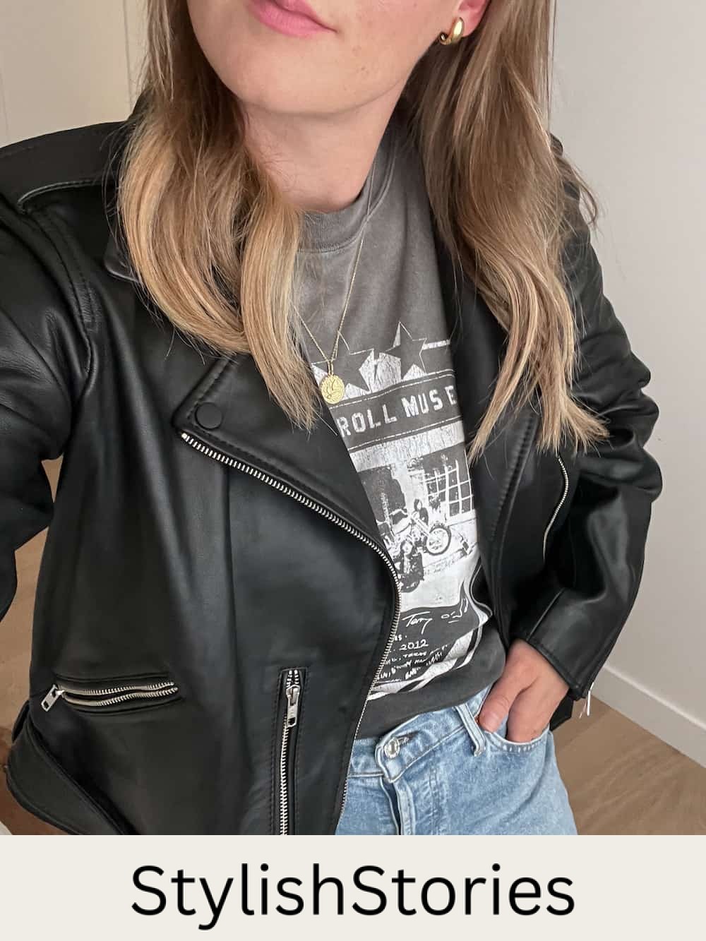 woman wearing a graphic tee with a leather jacket and jeans as part of a capsule wardrobe for fall