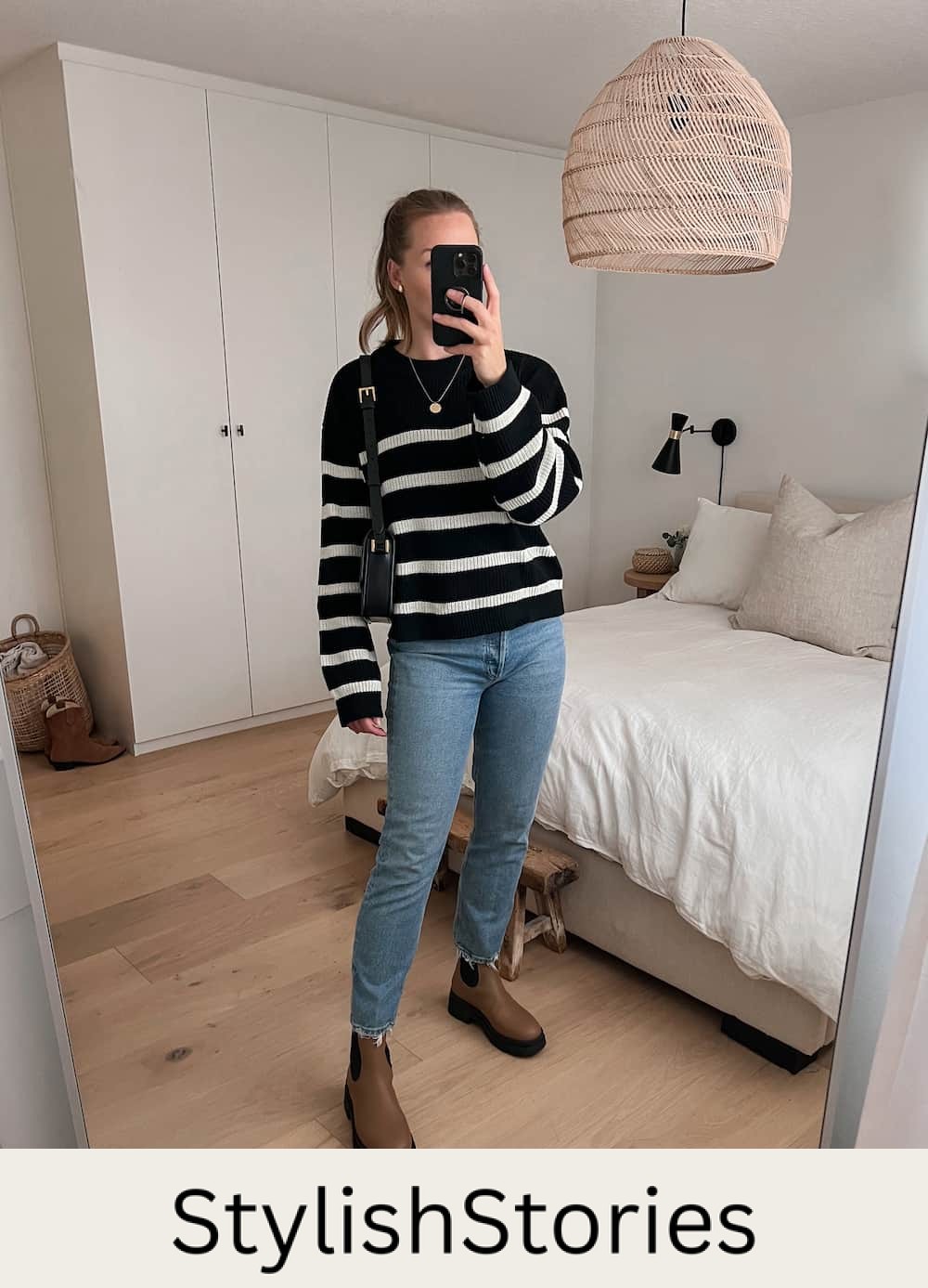 woman wearing a black and white striped knit sweater, jeans, and tan leather lug boots