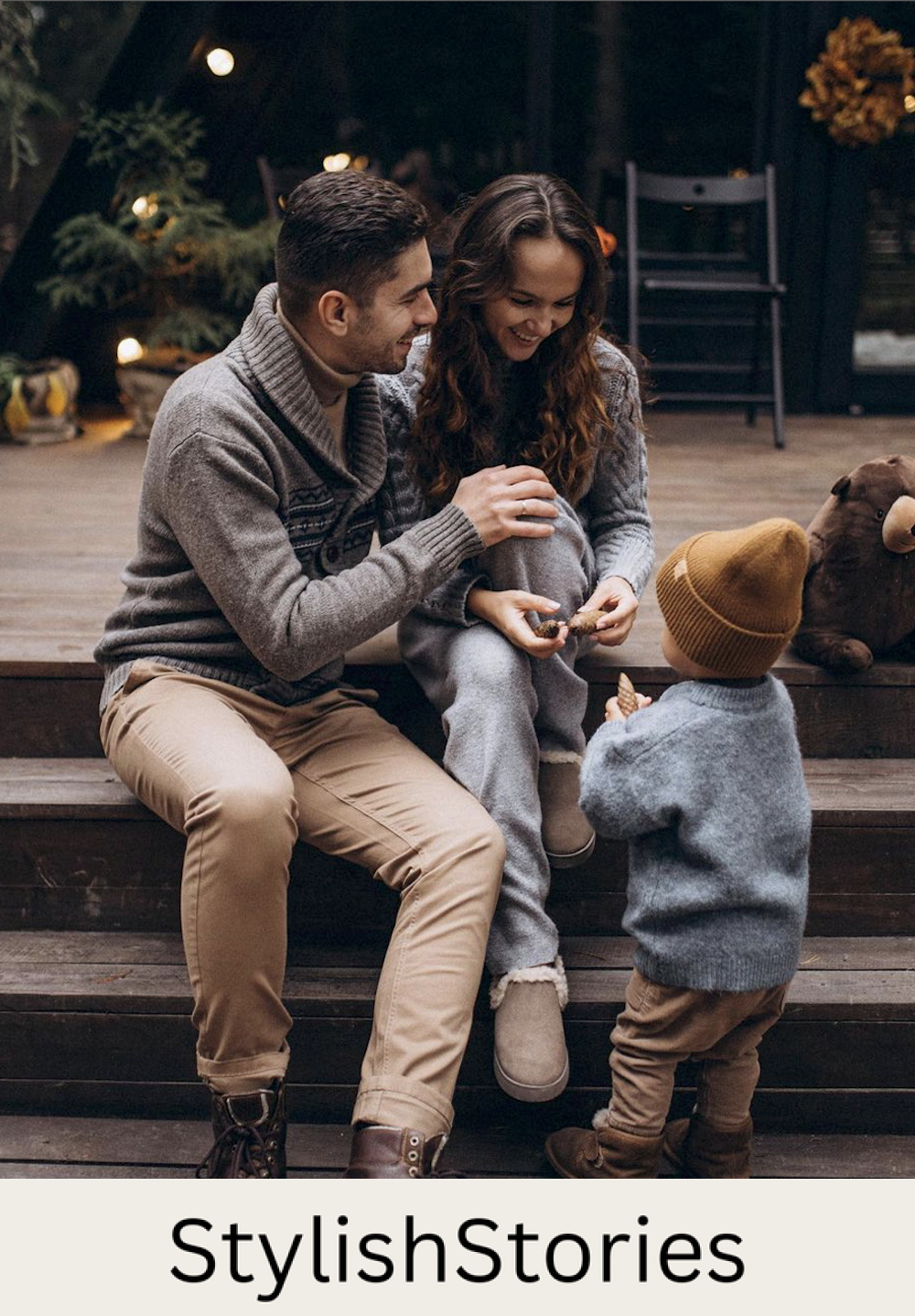 image of a man, woman, and small child in sweaters and pants sitting in front of a cabin for fall family photos