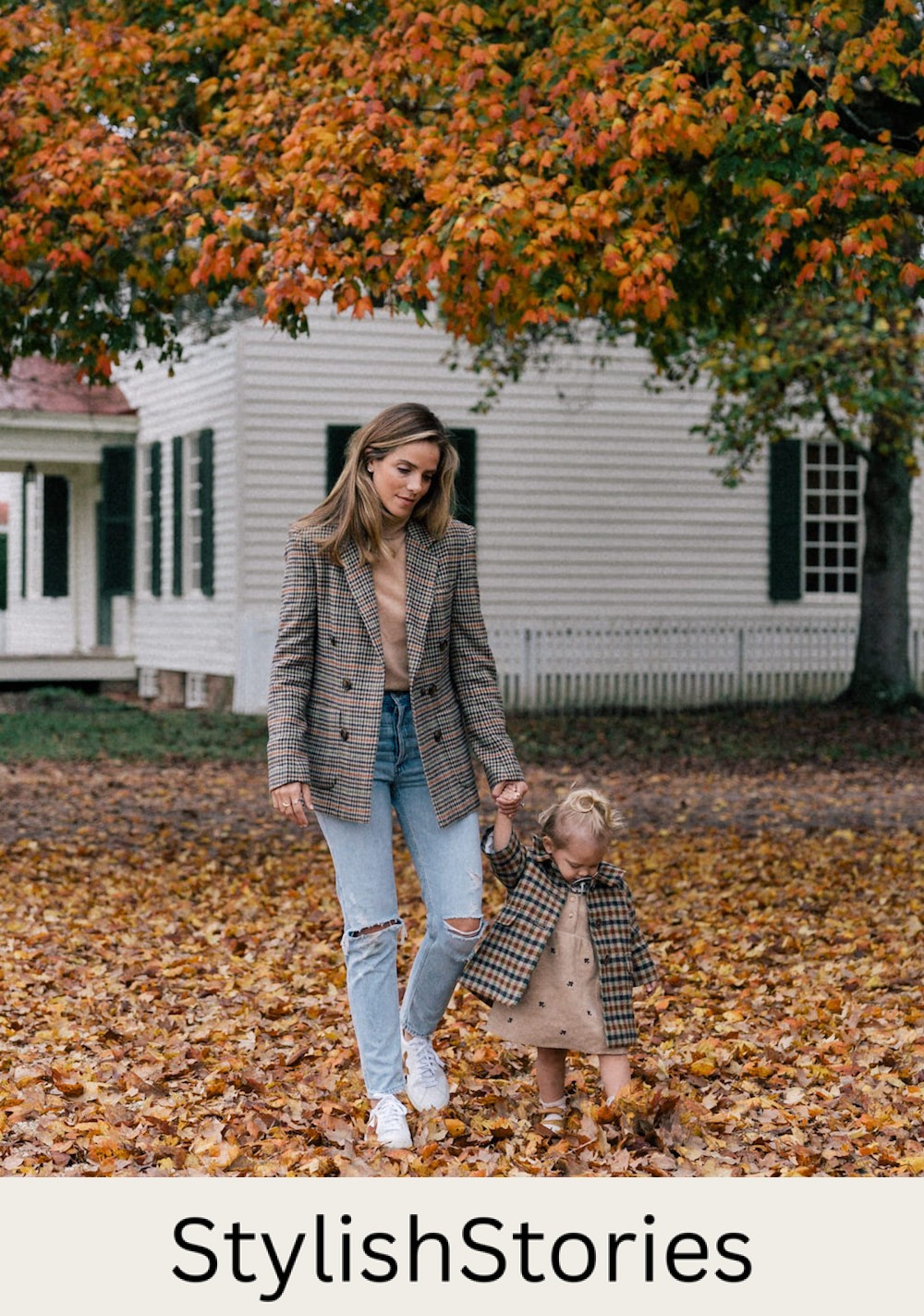 an image of a mother and daughter walking on a road with fallen leaves wearing plaid clothing and jeans