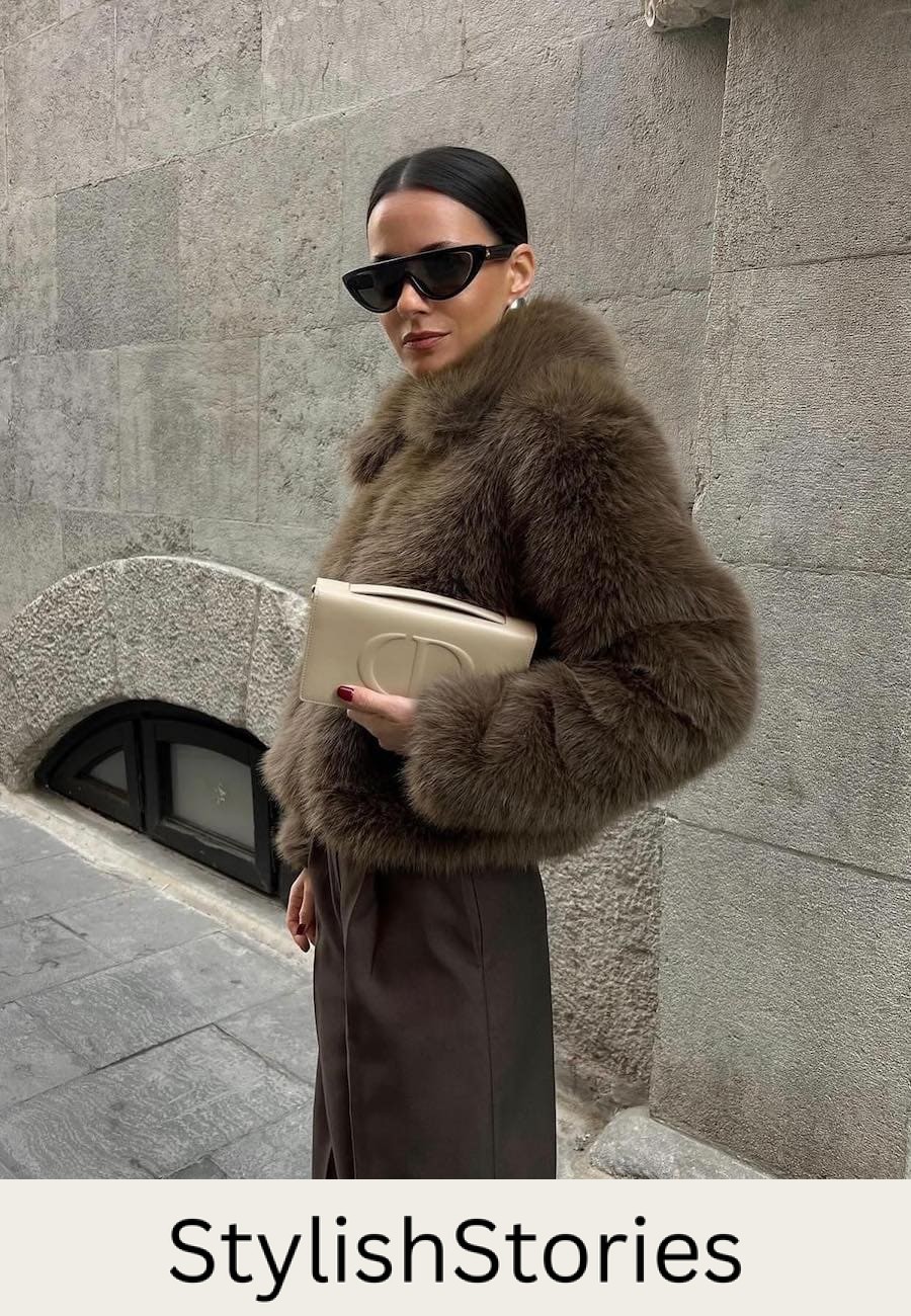 Woman wearing brown trousers with a brown fur coat.