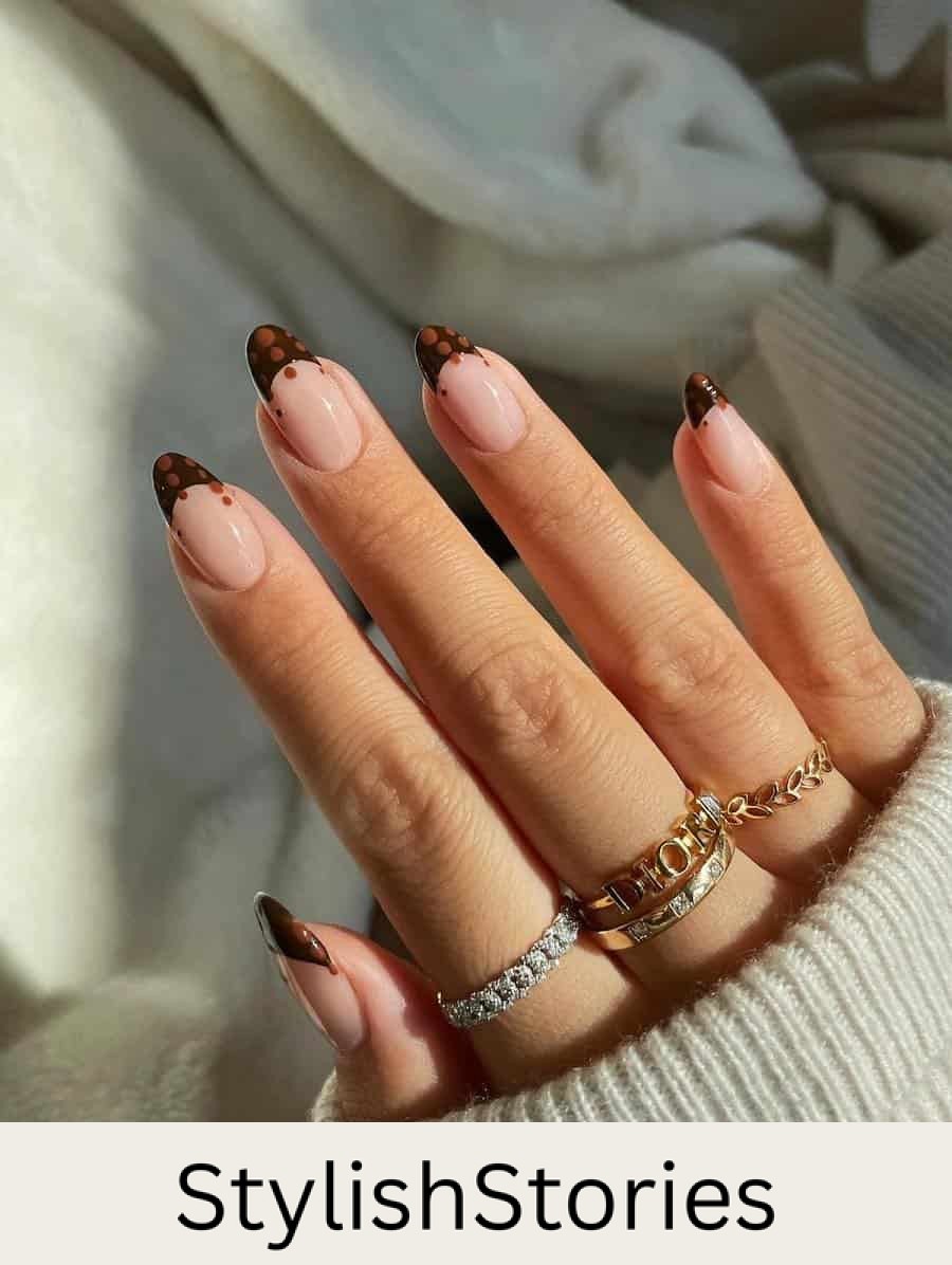medium nude almond nails with brown tips and light brown dot accents