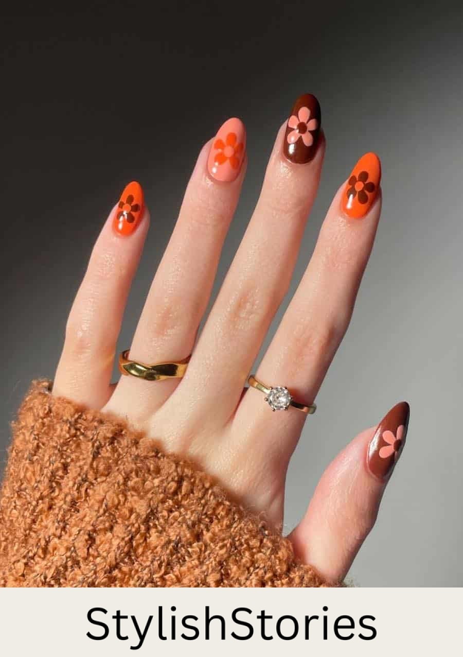 short almond nails featuring peach, orange, and brown nail polish with retro flowers