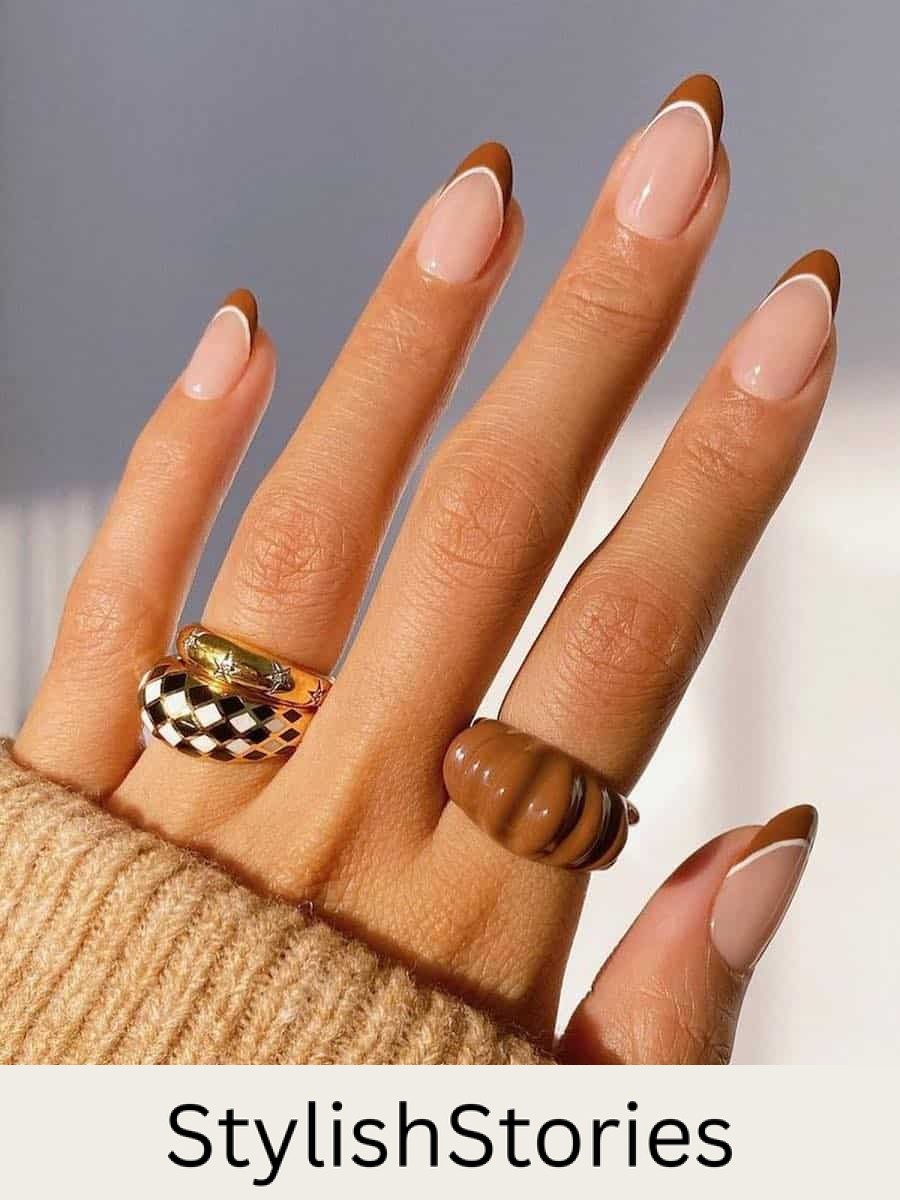 medium nude almond nails with light brown tips and white outlines