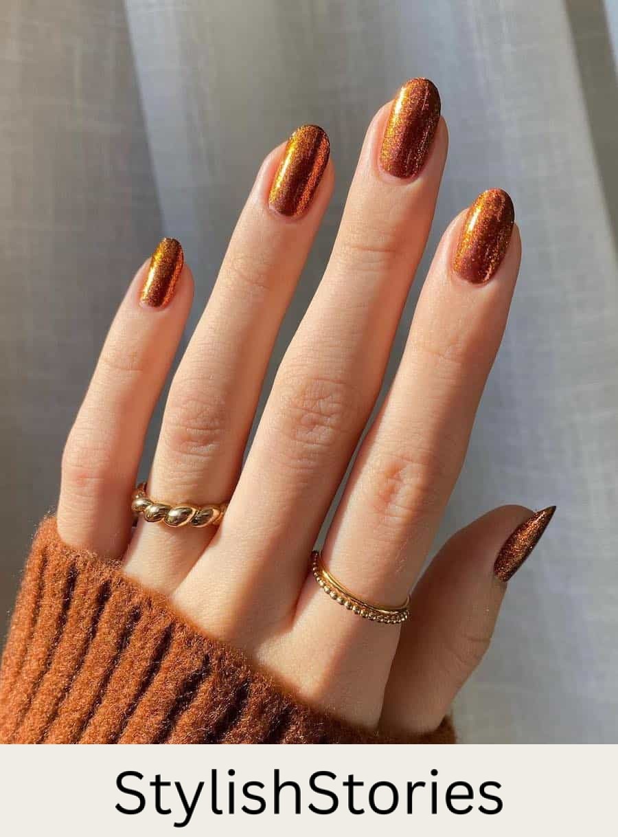 short round nails featuring shimmering copper colored nail polish